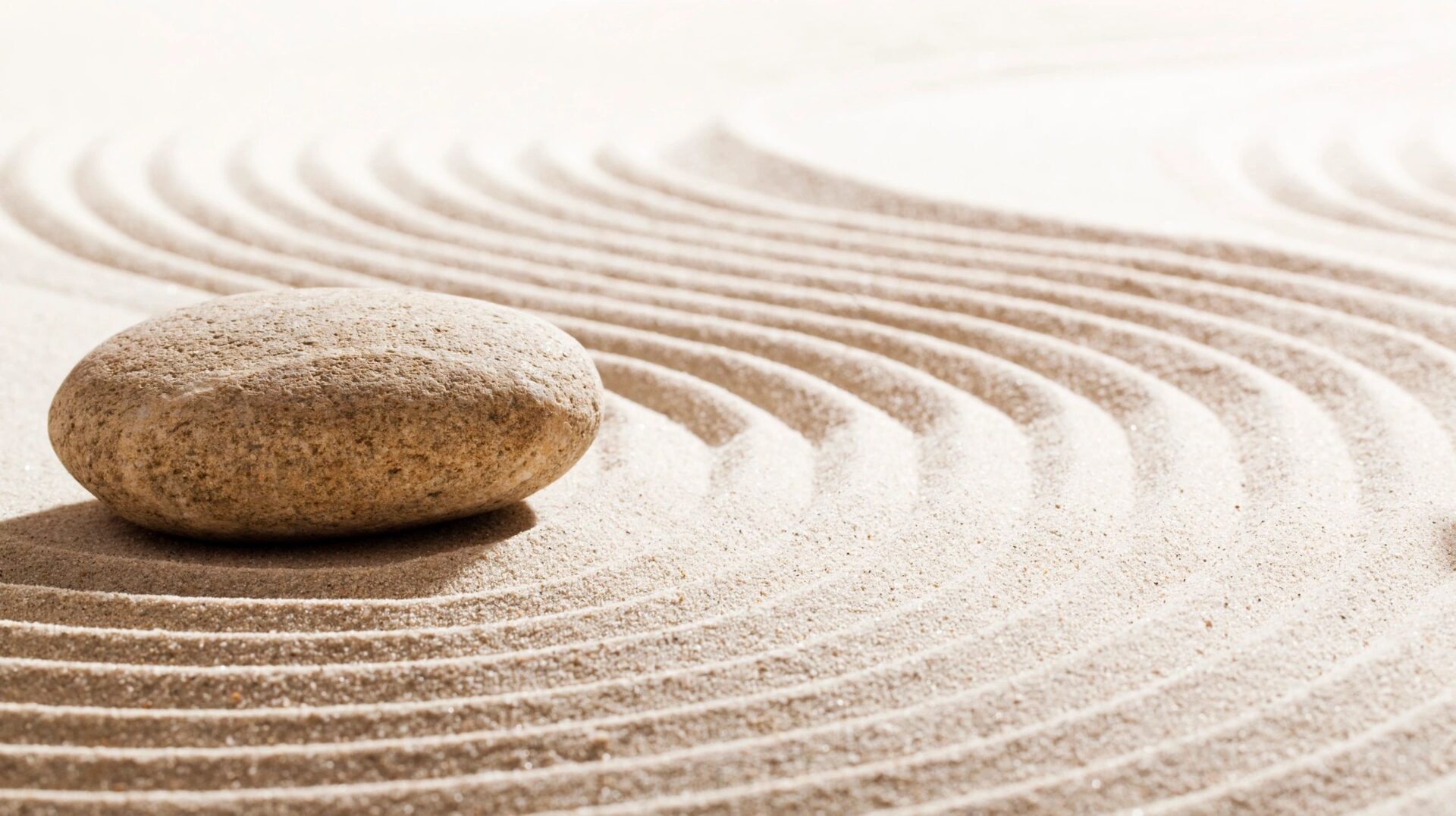 A rock sitting on top of sand in the middle of a circle.